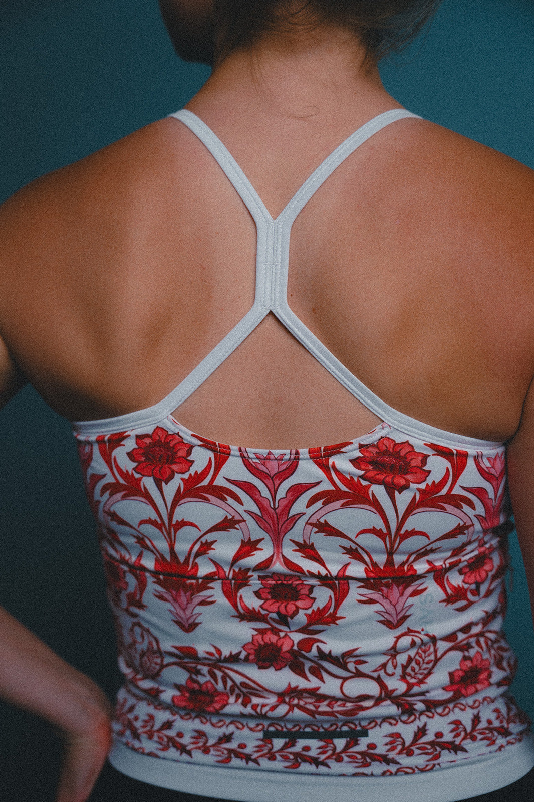 Cycling jersey with red floral pattern on a blue background.