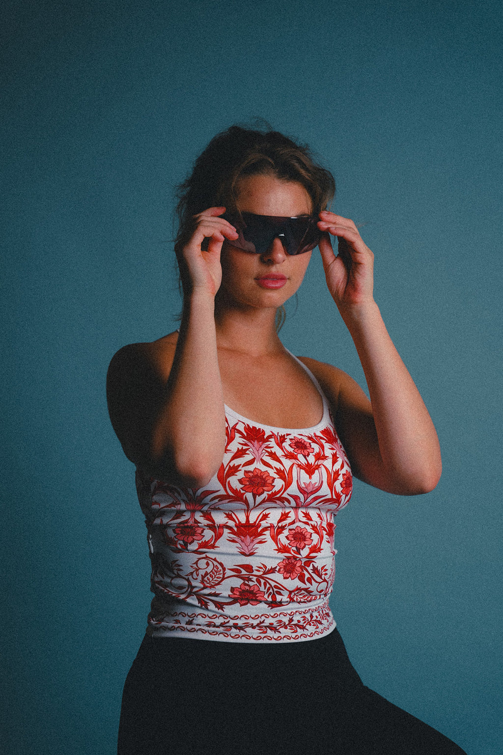 Woman wearing a red and white patterned cycling jersey against a blue background